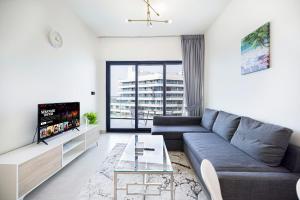 a living room with a couch and a tv at Homesgetaway - Ultraluxury 1BR in Binghatti Creek - Al Jaddaf in Dubai
