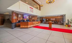 een grote lobby met een rode loper en een wachtruimte bij Treebo Trend Kapalin Resorts With Mountain View in Manāli