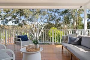 a porch with two couches and a table at Surf Lodge Avoca Beach Waterfront to Avoca Lake in Avoca Beach