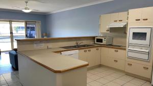 邦加里Ground floor, family unit on the canal with free WIFI!的配有白色橱柜和台面的厨房