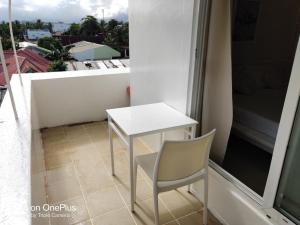 uma mesa branca e uma cadeira numa varanda em Mecasa Hotel em Boracay