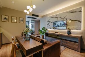 a living room with a couch and a table at Rak Elegant Hotel Patong - SHA Extra Plus in Patong Beach