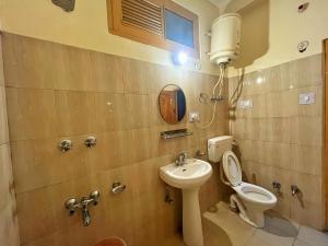 a small bathroom with a toilet and a sink at Hotel Anupam in Kasol