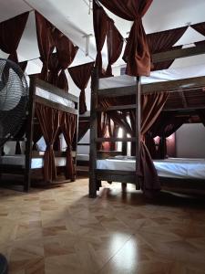 a room with three bunk beds with curtains at Alec Lodge in Coron