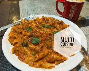 un plato de pasta en una mesa con una taza de café en Hotel Anupam, en Kasol