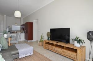 sala de estar con TV de pantalla plana grande en Apartment in Century City en Ciudad del Cabo