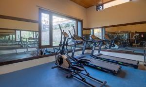 a gym with several cardio machines and a large window at Treebo Trend Kapalin Resorts With Mountain View in Manāli