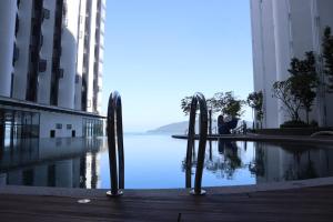 a pool in the middle of a building with a body of water at The Shore by Homesuite' in Kota Kinabalu