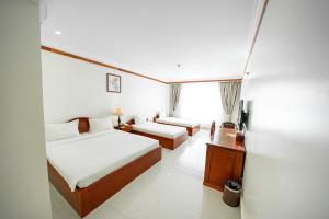 Pursat Riverside Hotel & Spa في Pursat: غرفة فندقية بسريرين وطاولة