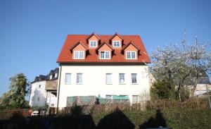 ein großes weißes Haus mit rotem Dach in der Unterkunft Ferienwohnung Zschopau Zentrum in Zschopau