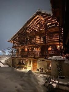 格雷索拉特里尼泰Wongade Chambres d'hotes e Restaurant的前面有雪的木制建筑
