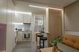 a small kitchen and living room with a table and chairs at Green and Grey loft 1 in Alexandroupoli +19 photos