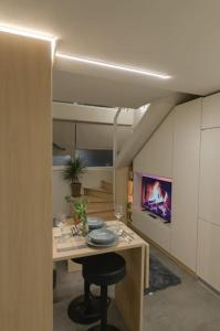 a room with a table with a chair and a tv at Green and Grey loft 1 in Alexandroupoli