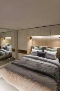 a bedroom with a large bed and a mirror at Green and Grey loft 1 in Alexandroupoli