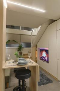 a kitchen with a table with a chair and a tv at Green and Grey loft 1 in Alexandroupoli