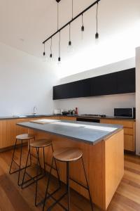 a kitchen with a large island with bar stools at Newtown Oasis w Parking & Air-con in Sydney