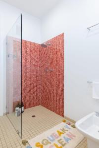 łazienka z prysznicem wyłożona czerwonymi kafelkami w obiekcie Newtown Oasis w Parking & Air-con w mieście Sydney