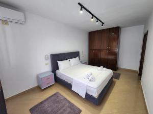 a bedroom with a large white bed with a wooden cabinet at Tirana Square Hotel in Tirana