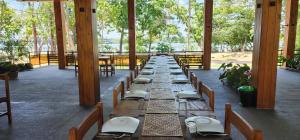 a long row of wooden tables in a building at Riviera Resort in Batticaloa