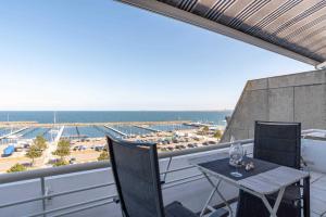 einen Balkon mit einem Tisch und Stühlen sowie Strandblick in der Unterkunft Ferienwohnung Hafen & Strand in Schilksee