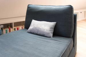 a blue chair with a pillow that says congratulations at Ferienwohnung Heimathafen in Strande