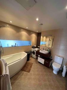 a bathroom with a tub and a toilet and a sink at Cozy apartment in peaceful area in Petrikyula