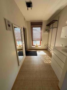 a kitchen with a hallway with a sink and a window at Cozy apartment in peaceful area in Petrikyula