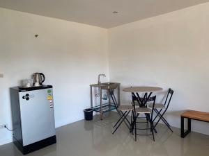 a kitchen with a table and a refrigerator and chairs at Dm-udon (ดีเอ็ม อุดรธานี) in Udon Thani +12 photos