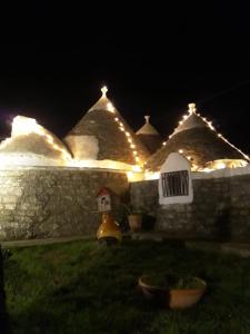 マルティナ・フランカにあるTrullo Mauro MGG - Trullo Fragaleの夜の屋根の灯りを持つ家