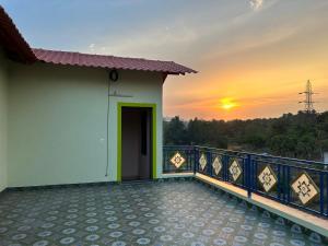 a balcony of a house with the sunset in the background at Asmi Palace, Bhaimala, Alibag in Vāgholi
