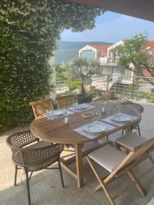 drewniany stół i krzesła na patio w obiekcie Acacia Hill Apartment C01 w mieście Ðenovići