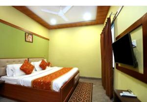 - une chambre avec un lit et une télévision à écran plat dans l'établissement $4 HOME STAY (5 MINT WALK FROM GOLDEN TEMPLE), à Amritsar