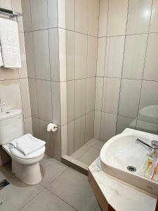 a bathroom with a toilet and a sink and a shower at d'primahotel Jemursari Surabaya in Surabaya