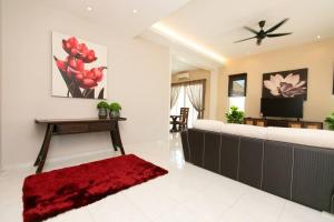 sala de estar con sofá y alfombra roja en BalikPulau Cozy Home 4BR w BBQ, en Balik Pulau