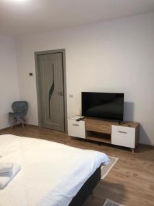 een slaapkamer met een bed en een flatscreen-tv bij STEFANIA in Piatra Neamţ