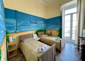 2 letti in una camera con pareti blu di Casa di Chiara a Crotone