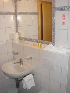 ein weißes Badezimmer mit einem Waschbecken und einem Spiegel in der Unterkunft Chasa Larets in Samnaun