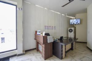 een kantoor met een bureau en een televisie aan een muur bij Flagship 71214 Hotel Welcome Inn in Ludhiana