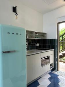 a kitchen with white cabinets and a refrigerator at Yaho Beach House in Jeju