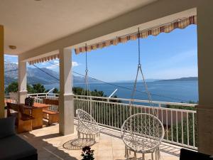 een balkon met stoelen en uitzicht op het water bij Omiš Relaxing Sea Lounge in Marusici 
