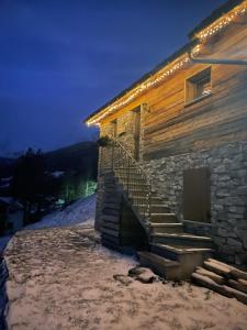 a building with stairs on the side of it with lights at Baita Chalet La Masun in Chiesa in Valmalenco