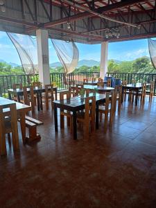 a restaurant with tables and chairs with a view at Alec Lodge in Coron