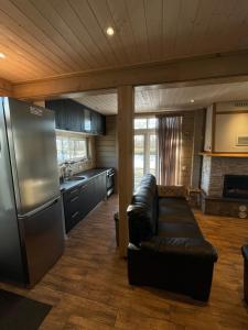 a kitchen with a leather couch and a refrigerator at Ermistu Puhkeküla in Ermistu
