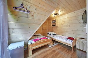 a room with two beds in a log cabin at Dom Rodzinny in Ząb