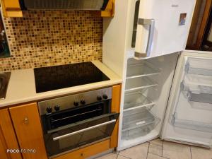eine Küche mit einem Backofen und einem offenen Kühlschrank in der Unterkunft APARTMENTS by climbing house in Kalymnos
