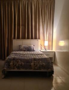 a bedroom with a bed and a window with curtains at بيت الياسمين2 in Al Madinah