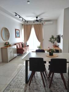 ein Wohnzimmer mit einem Tisch, Stühlen und einem Sofa in der Unterkunft MamaQarl Homestay@KLIA&PICC+ Wi-Fi+Neflix 7pax in Sepang
