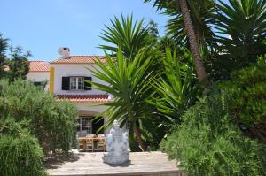 a statue in front of a house with palm trees at House near Ribeira with Garden, Terrace & Yoga Studio in Santo Isidoro