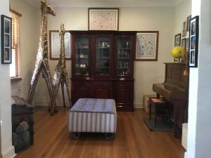 sala de estar con jirafas y piano en A Homestead on Market, en Mudgee