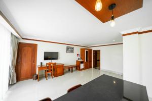 a dining room with a table and a television at Pursat Riverside Hotel & Spa in Pursat